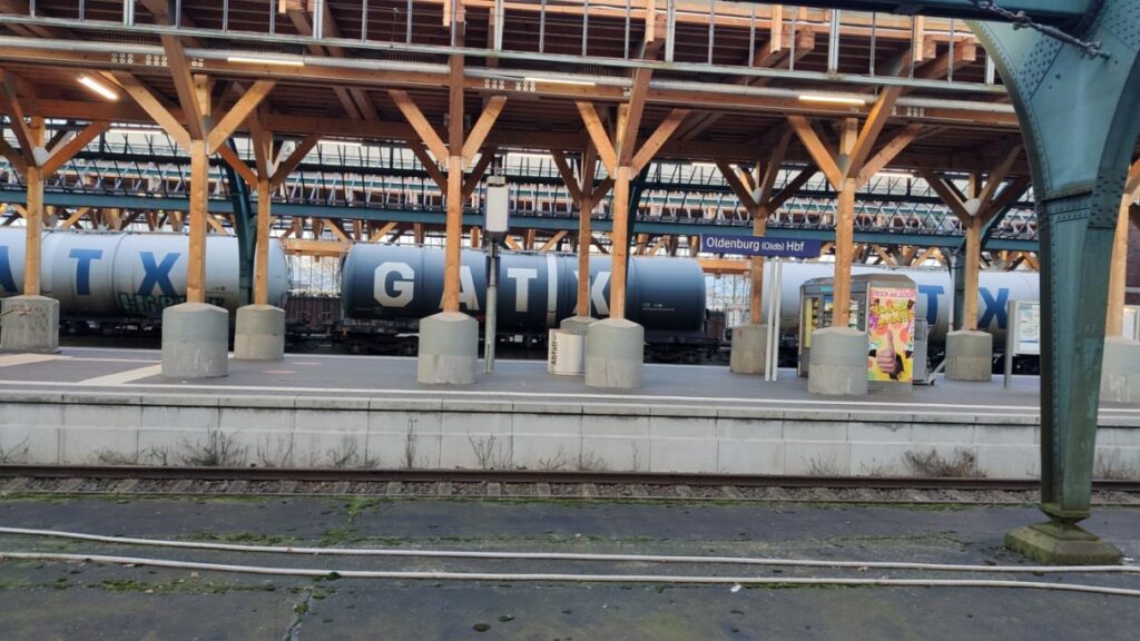 Oldenburg Hauptbahnhof Gleishalle Holz-Provisorium auf massiven Beton-Sockeln im Hintergrund Skelett denkmalgeschützte Gleishalle